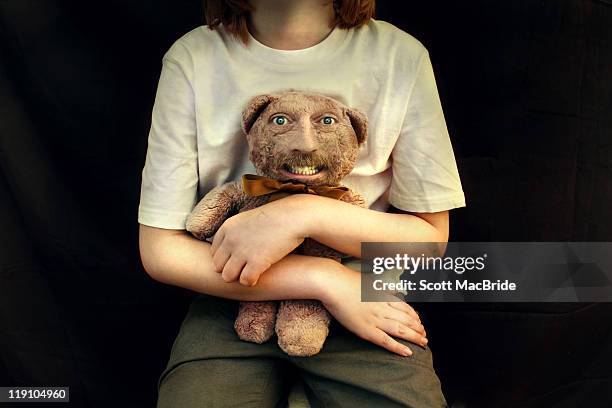 Girl holding teddy bear with freaky human face