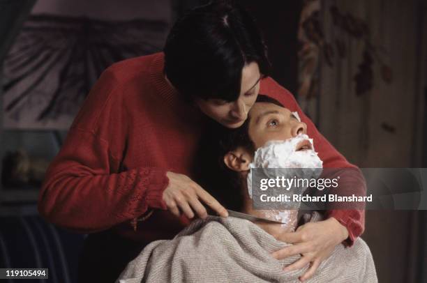 American actor James Spader stars with French actress Anne Brochet in the film 'Driftwood', 1997. In this scene, she gives him a wet shave with a...