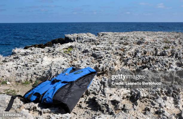 Discarded life jacket with the remains of a migrant's boat barely landed at Punta Sottile on October 21,2019 in Lampedusa,Italy. Lampedusa the...