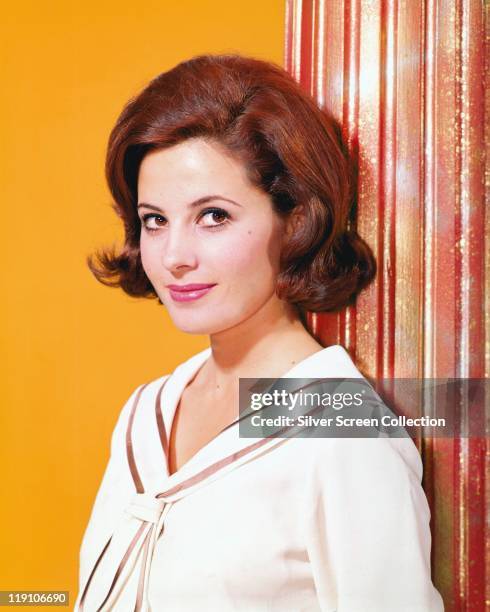 Barbara Parkins, Canadian actress, posing beside a curtain in a studio portrait, against a yellow background, circa 1965.