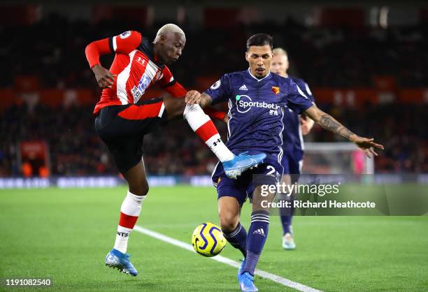 Moussa Djenepo of Southampton crosses the ball under pressure from Jose Holebas of Watford during the Premier League match between Southampton FC and...