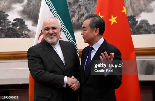 China's Foreign Minister Wang Yi shakes hands with Iran's Foreign Minister Mohammad Javad Zarif during a meeting at the Diaoyutai state guest house...