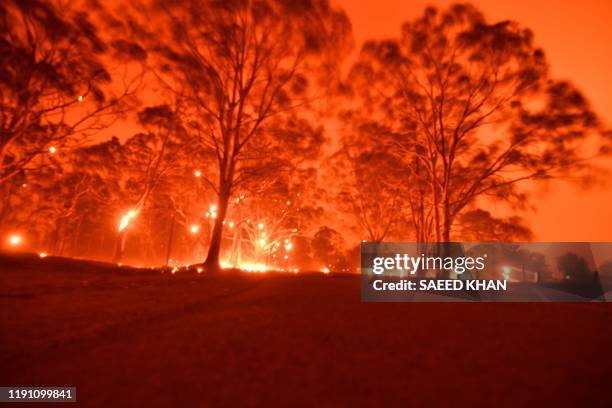 The afternoon sky glows orange from bushfires in the area around the town of Nowra in the Australian state of New South Wales on December 31, 2019. -...