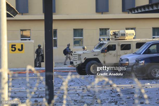 Soldiers stand guard as outraged Iraqi protesters storm the U.S. Embassy in Baghdad, protesting Washington's attacks on armed battalions belong to...