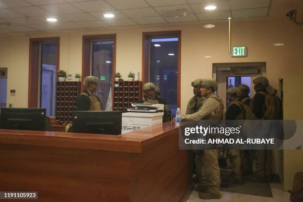 American soldiers are seen through a window inside the US embassy in Iraq's capital Baghdad, on December 31 as supporters and members of the Hashed...