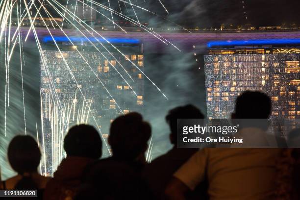 Visitors watch fireworks display at Marina Bay as Singapore count down to New Year 2020 on December 31, 2019 in Singapore.