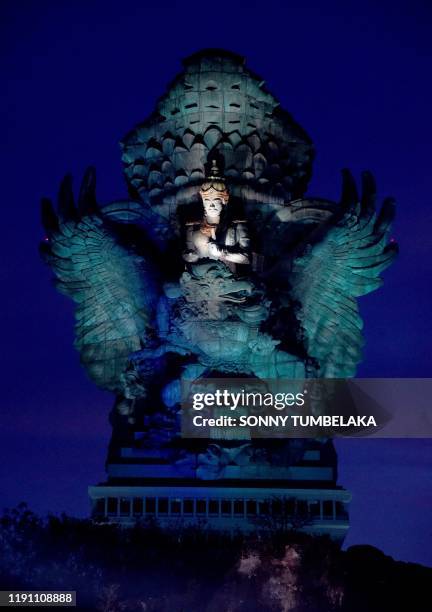This pictures taken on December 31, 2019 shows a general view of the 122-metre tall Garuda Wisnu Kencana statue lit up late at night before a New...
