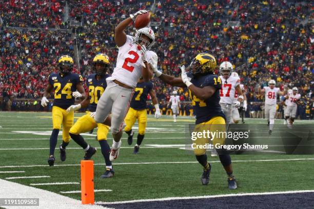 Dobbins of the Ohio State Buckeyes dives for a fourth quarter touchdown past Josh Metellus of the Michigan Wolverines at Michigan Stadium on November...