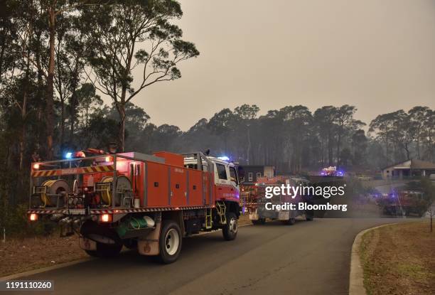 New South Wales Rural Fire Service vehicles stand along a road in Batemans Bay, New South Wales, Australia, on Tuesday, Dec. 31, 2019....
