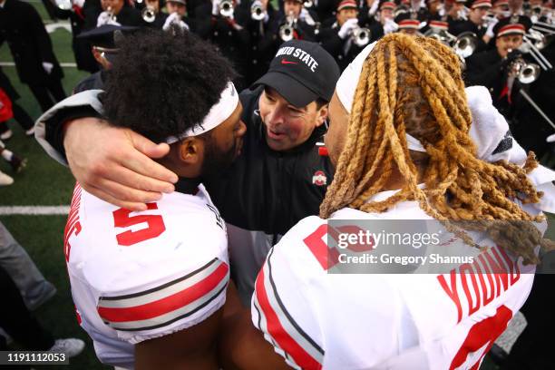 Head coach Ryan Day of the Ohio State Buckeyes celebrates a 57-27 win over the Michigan Wolverines with Chase Young and Baron Browning at Michigan...