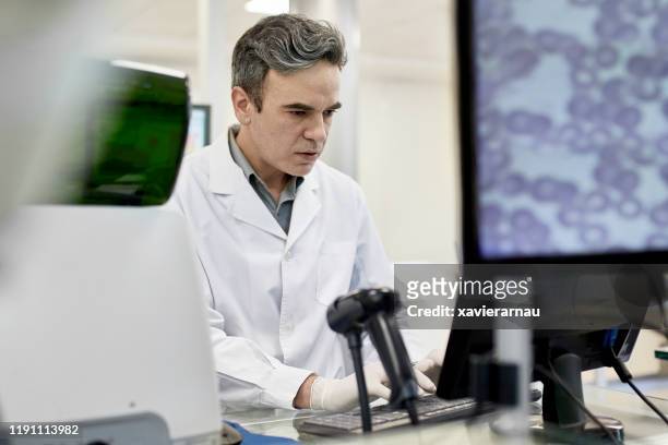 gerichte mannelijke patholoog op het werk in klinisch analyselaboratorium - patholoog stockfoto's en -beelden