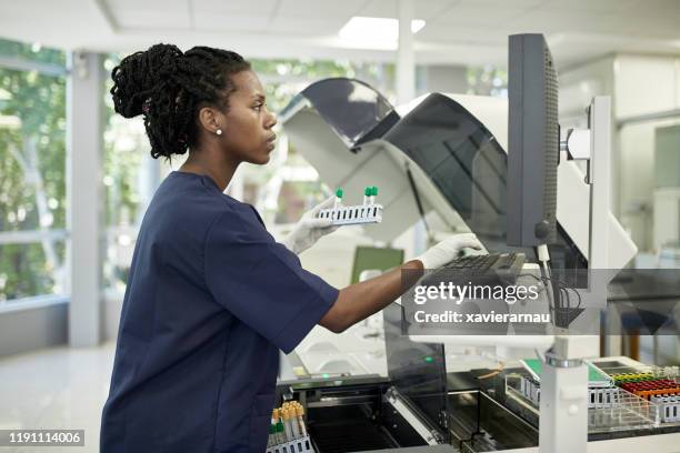 african pathology technician working on computer in lab - medical research blood stock pictures, royalty-free photos & images
