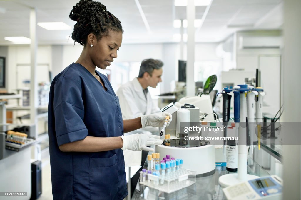 Young African Female Pathology Technician Working in Lab