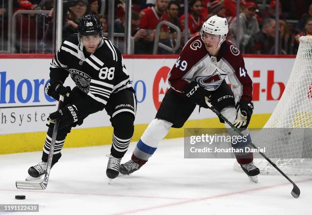 Patrick Kane of the Chicago Blackhawks looks to pass under pressure from Samuel Girard of the Colorado Avalanche at the United Center on November 29,...