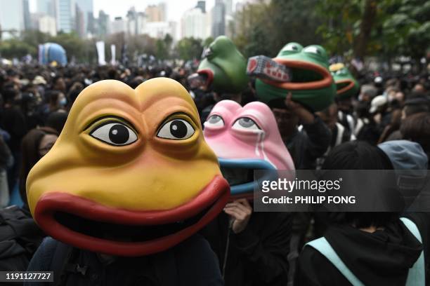 Activists wear Pepe the Frog masks, a character used by pro-democracy activists as a symbol of their struggle, as they gather in Victoria Park in the...