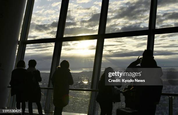 People watch the year's first sunrise at the observation deck of Tokyo Skytree on Jan. 1, 2020.