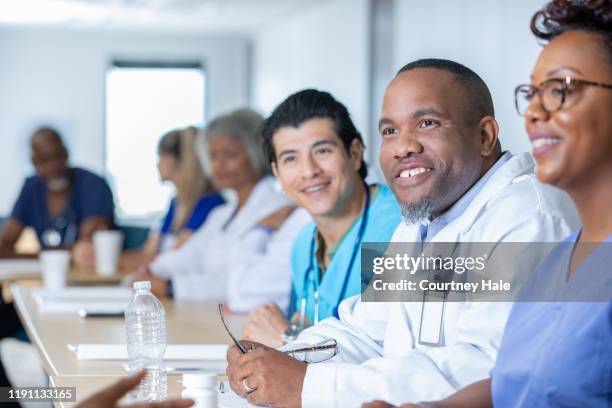 medical staff meeting in conference room - civilian stock pictures, royalty-free photos & images