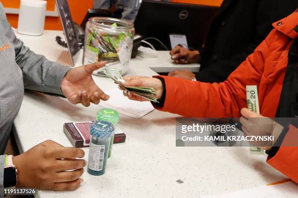 Customer Elise Swopes makes a purchase at Sunnyside Cannabis Dispensary on January 1, 2020 in Chicago, Illinois. - On the first day of 2020,...
