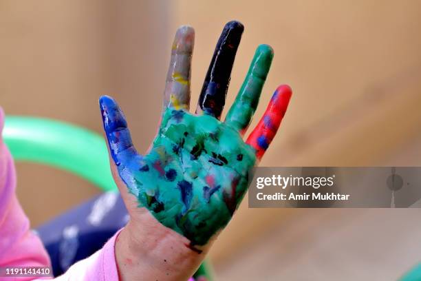 showing painted palm of hand with multi watercolors by herself - 9 hand drawn patterns stock-fotos und bilder