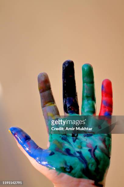showing painted palm of hand with multi watercolors by herself - 9 hand drawn patterns stock-fotos und bilder