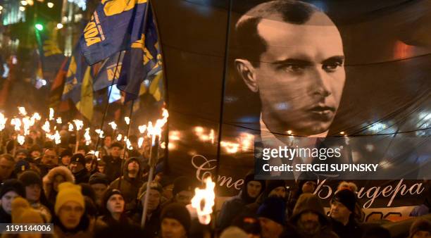 People carry torches during the "March of Honor, Dignity and Freedom" in Kiev on January 1, 2020 to mark the 111th anniversary of the birth of...