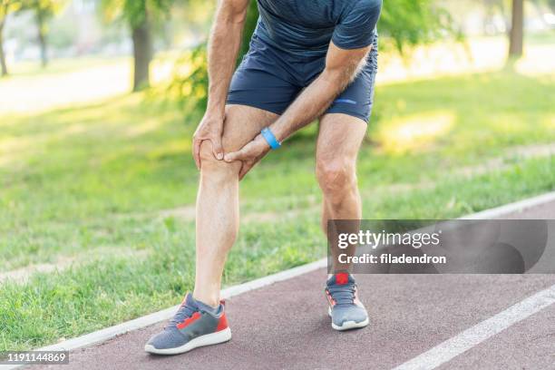 sports injury - standing with hands on knees imagens e fotografias de stock