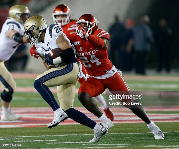 Keoni-Kordell Makekau of the Navy Midshipmen is tackled fro behind by Donavan Mutin of the Houston Cougars on November 30, 2019 in Houston, Texas.