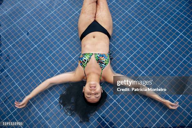 mulher em momento de relaxamento na piscina, com suas cicatrizes à mostra - mulher piscina stock pictures, royalty-free photos & images