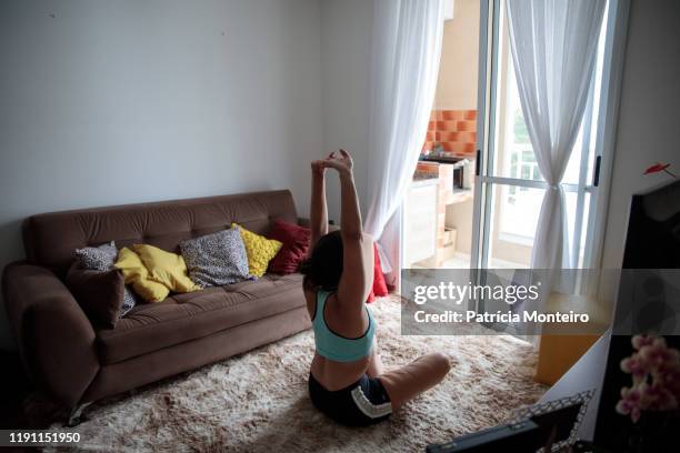 mulher praticando ioga na sala de sua casa, com suas cicatrizes à mostra - praticando 個照片及圖片檔