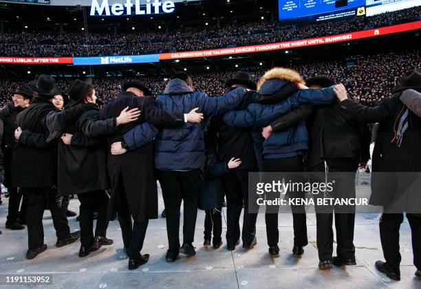 Men dance as they gather with others in MetLife Stadium on January 1 in East Rutherford, New Jersey, to mark the Siyum HaShas, an event that...
