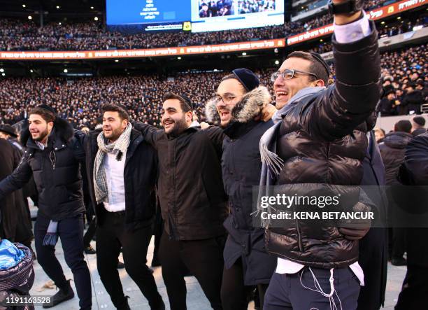 Men dance as they celebrate Siyum HaShas, the completion of the reading of the Babylonian Talmud, at the MetLife Stadium on January 1 in East...