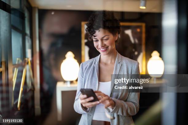 una mujer de negocios de pie en el pasillo de un hotel - actividad económica fotografías e imágenes de stock