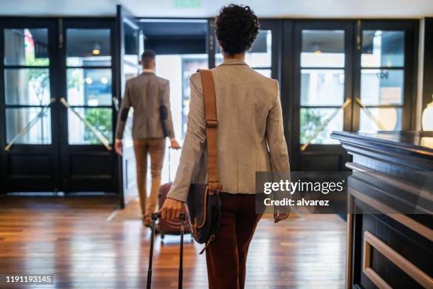 uomini d'affari con bagagli che lasciano l'hotel - leaving foto e immagini stock