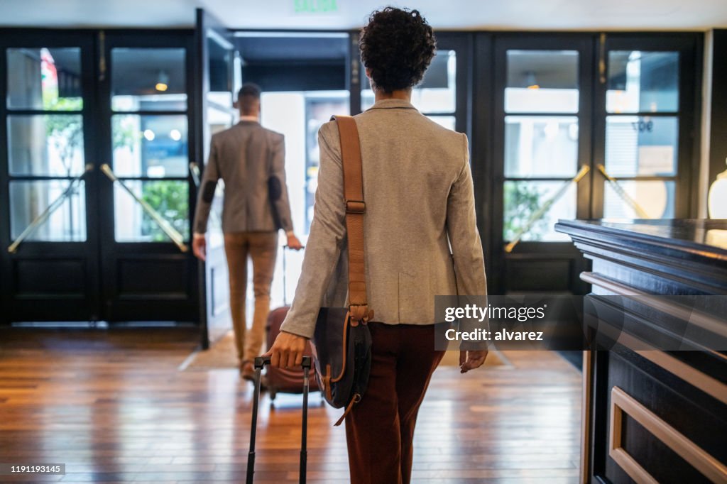 Business people with luggage leaving the hotel