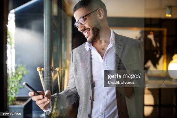 businessman booking an online taxi from his phone - booking hotel stock pictures, royalty-free photos & images