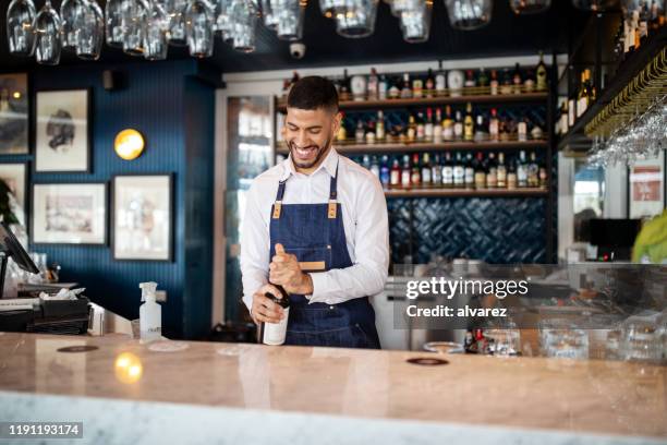 happy young barman werkt aan de bar - barmen stockfoto's en -beelden