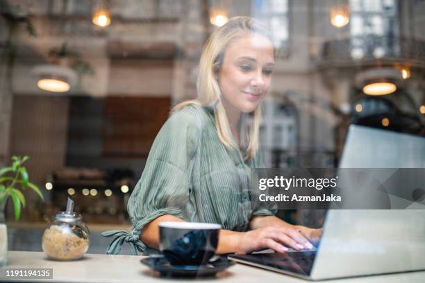 relaxed young businesswoman working on laptop in cafe - personal perspective view stock pictures, royalty-free photos & images