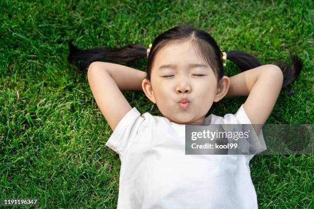 cute girl lying down on the lawn - child yoga elevated view stock pictures, royalty-free photos & images