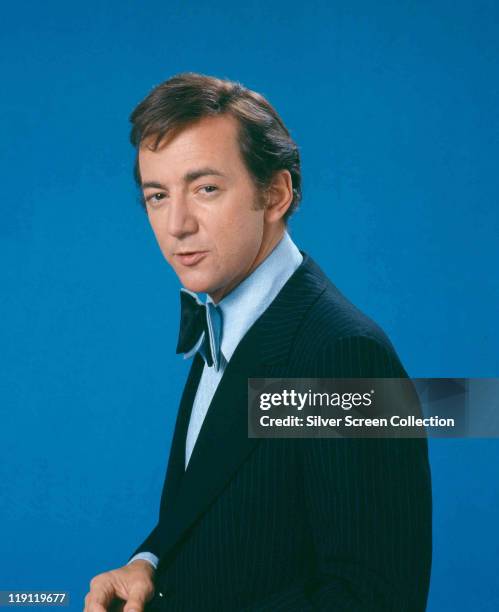 Bobby Darin , US singer and actor, wearing a dark blue pin-striped jacket, a light blue shirt and dark blue bowtie in a studio portrait, against a...