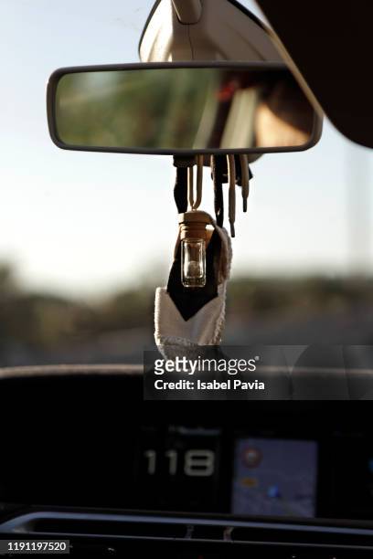air freshener and little shoe hanging on a rearview mirror - car air freshener stock-fotos und bilder