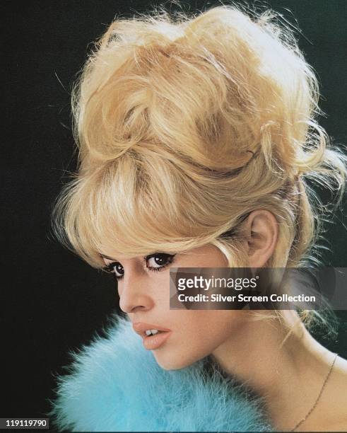 French actress, Brigitte Bardot, with a bouffant hairstyle and a blue boa, 1960.