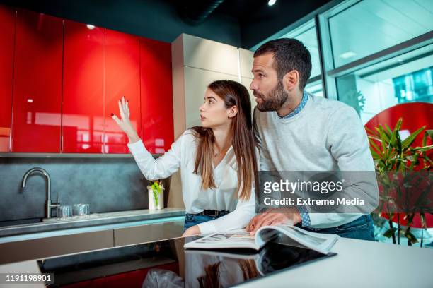 giovane coppia che pianifica insieme la loro nuova cucina in un negozio fai-da-da-casa - mobilio foto e immagini stock