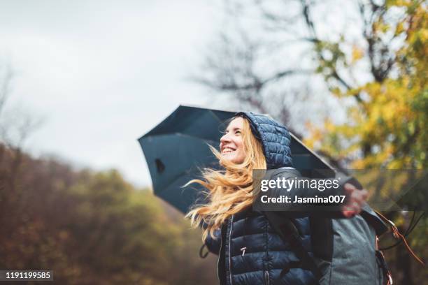 schöne junge frau genießt einen regnerischen tag - umbrella rain stock-fotos und bilder