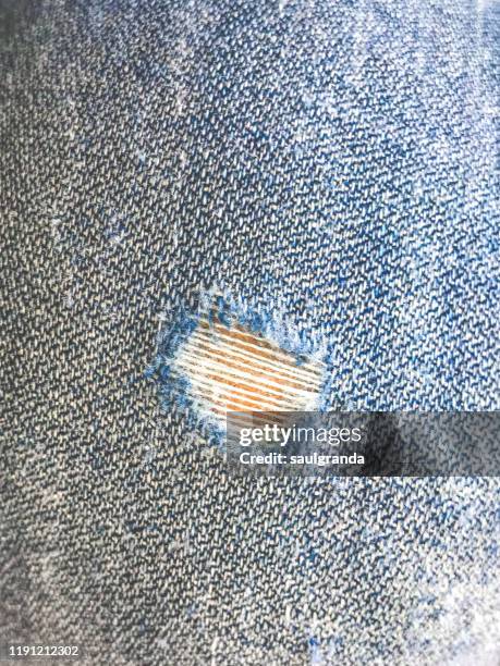 close-up of a hole in jeans - frayed fabric stock pictures, royalty-free photos & images