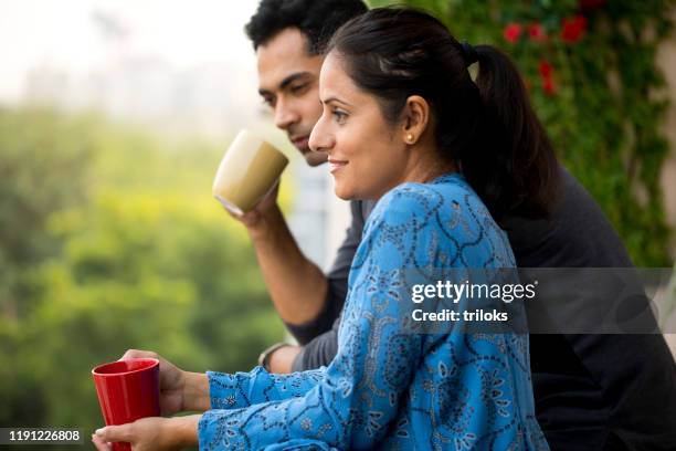 glückliches paar trinkt kaffee auf dem balkon - tee indien trinken stock-fotos und bilder