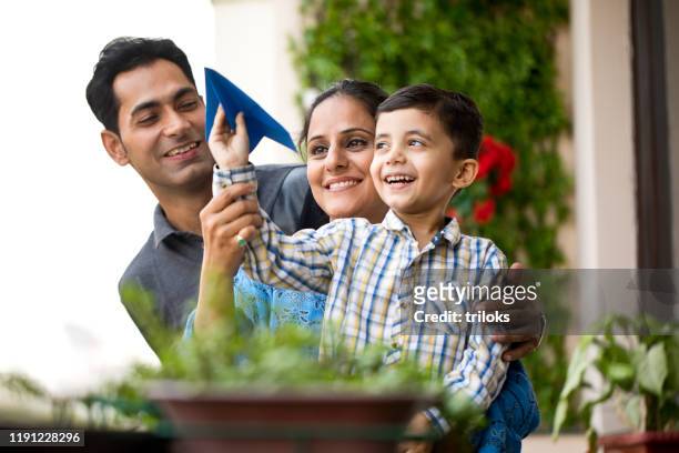 indian family playing with paper airplane - india stock pictures, royalty-free photos & images