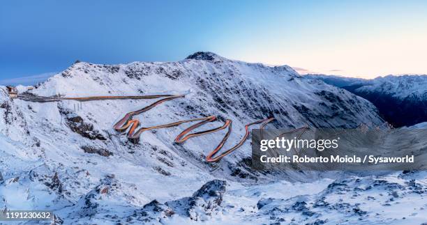 car trails lights on bends of stelvio pass mountain road, south tyrol, italy - stelvio pass stock pictures, royalty-free photos & images