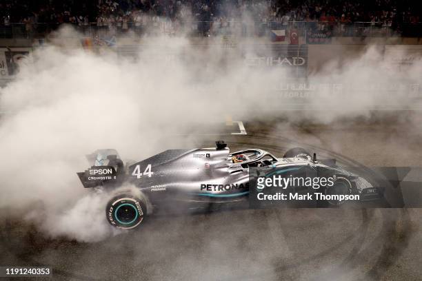 Race winner Lewis Hamilton of Great Britain and Mercedes GP celebrates with donuts on track during the F1 Grand Prix of Abu Dhabi at Yas Marina...