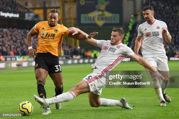 Jack O'Connell of Sheffield United tackles Adama Traore of Wolverhampton Wanderers during the Premier League match between Wolverhampton Wanderers...