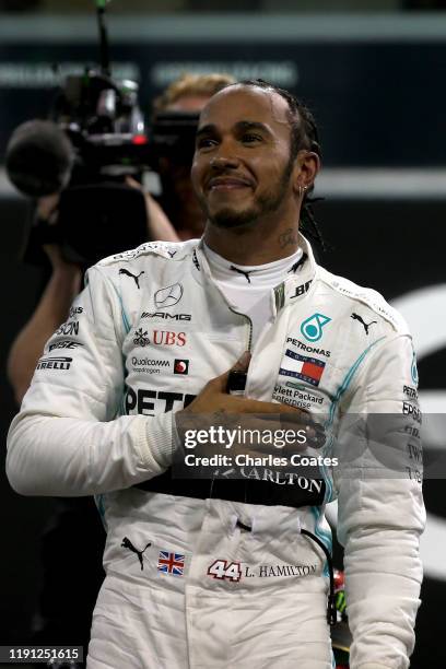 Race winner Lewis Hamilton of Great Britain and Mercedes GP celebrates in parc ferme during the F1 Grand Prix of Abu Dhabi at Yas Marina Circuit on...